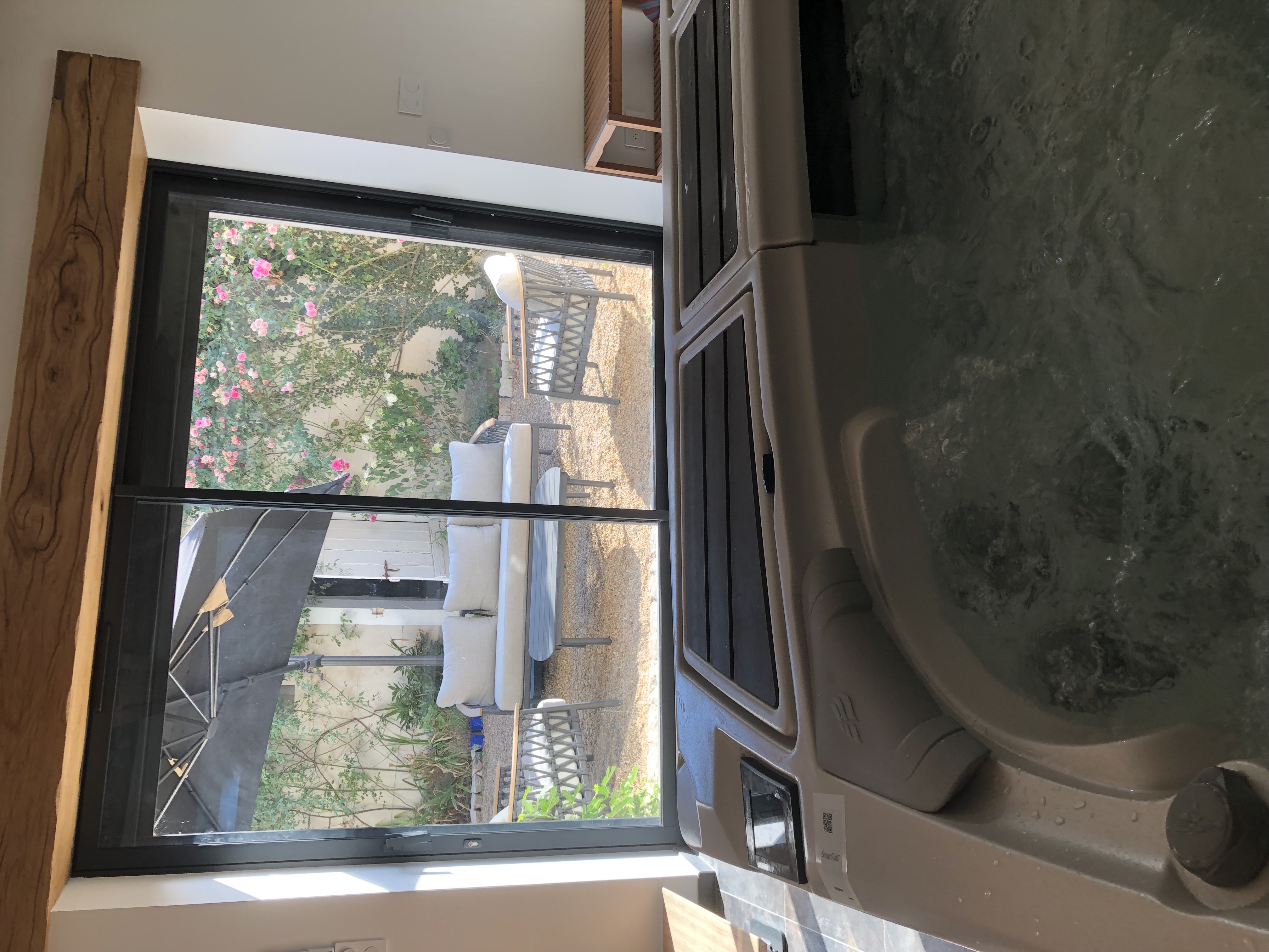 Terrasse en bois avec salon de jardin et jacuzzi rond
